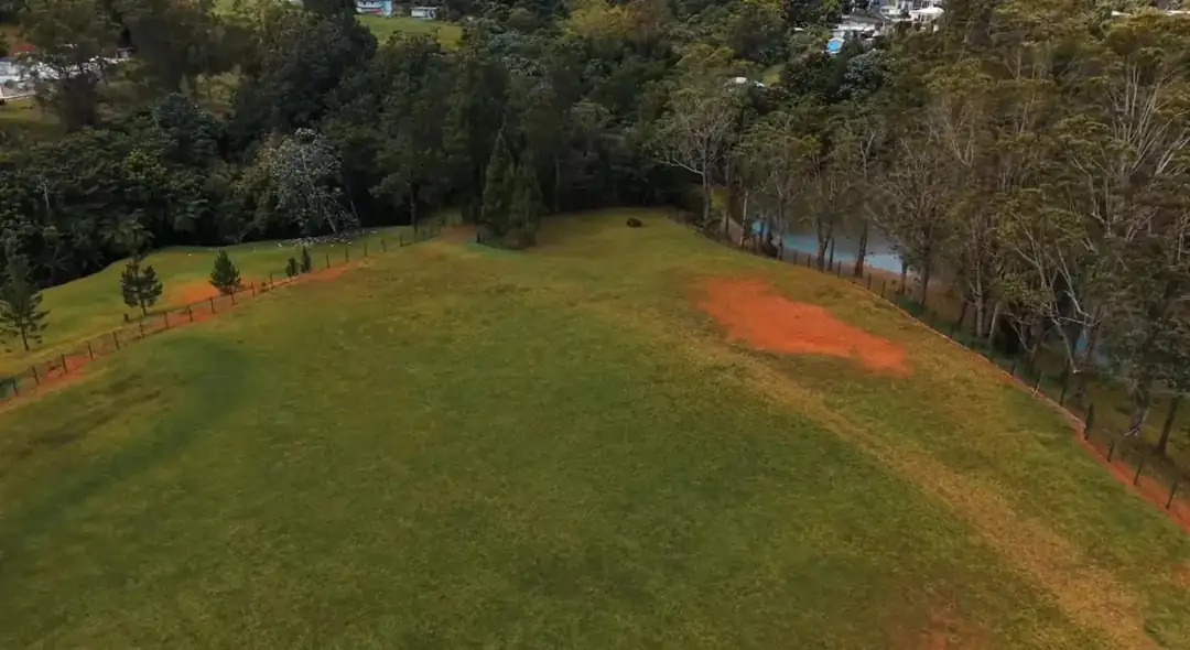 Vista de los terrenos, árboles y un cuerpo de agua en Campo Santo El Paraíso.