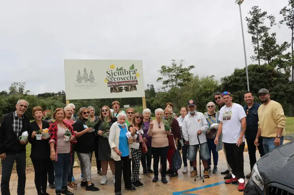 Foto de grupo frente al rótulo del huerto